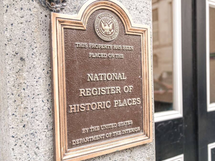 A plaque on a building wall stating it is a National Register of Historic Places.