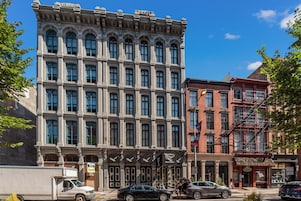 Um edifício histórico com grandes janelas e estilo arquitetônico clássico, com placa indicando um restaurante e um barbeiro.