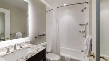 A bathroom with a white sink, toilet, and bathtub. There is a shower curtain and a towel rack with towels.