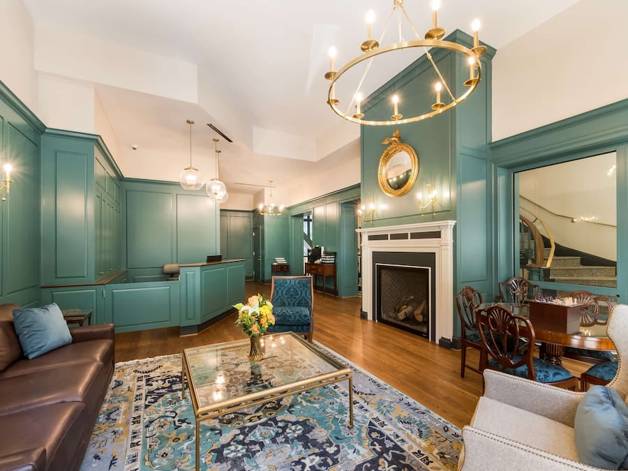 A spacious living room with teal walls, a fireplace, and a dining area with wooden furniture.