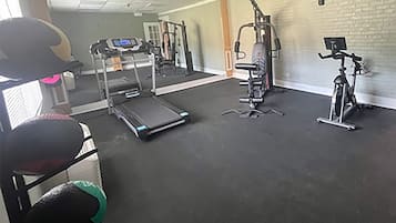 A gym with a treadmill, elliptical, and stationary bike.