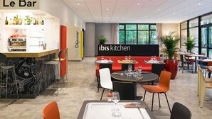 A modern hotel lobby with a bar area, seating, and a view of greenery outside. - ibis Nancy Brabois (Vandœuvre-lès-Nancy)