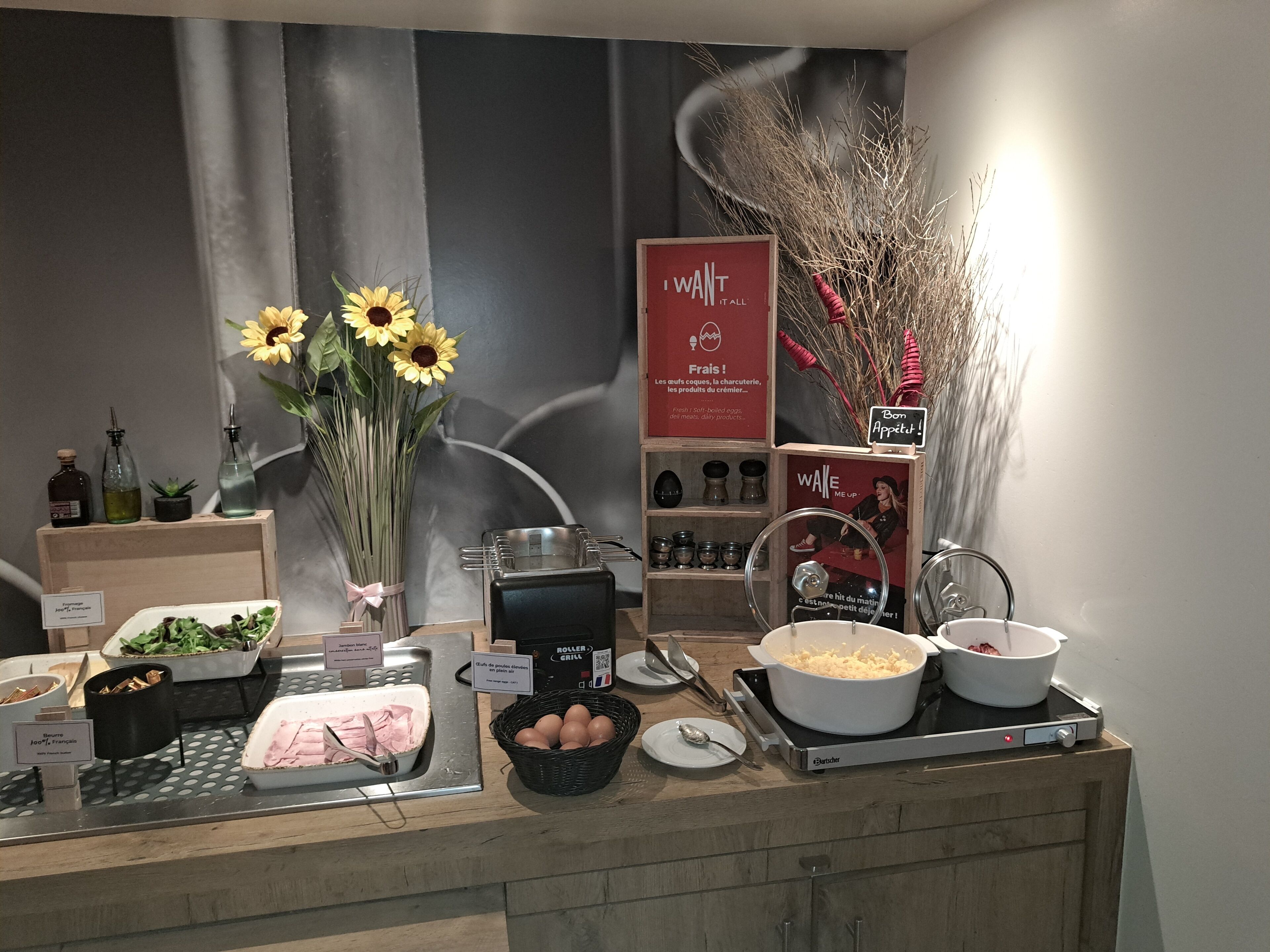 A buffet setup with various food items, including a salad bar, a bowl of eggs, and a pot of soup.