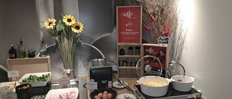 A buffet setup with various food items, including a salad bar, a bowl of eggs, and a pot of soup.