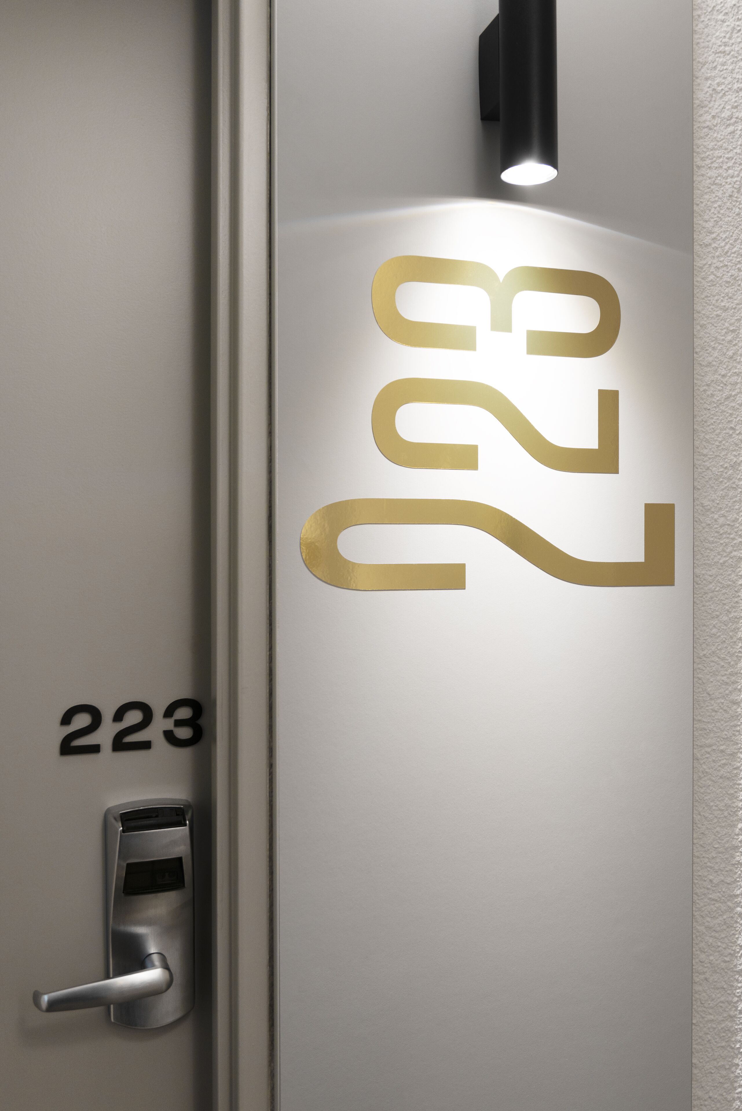 A door with a number "223" and a modern keycard reader.