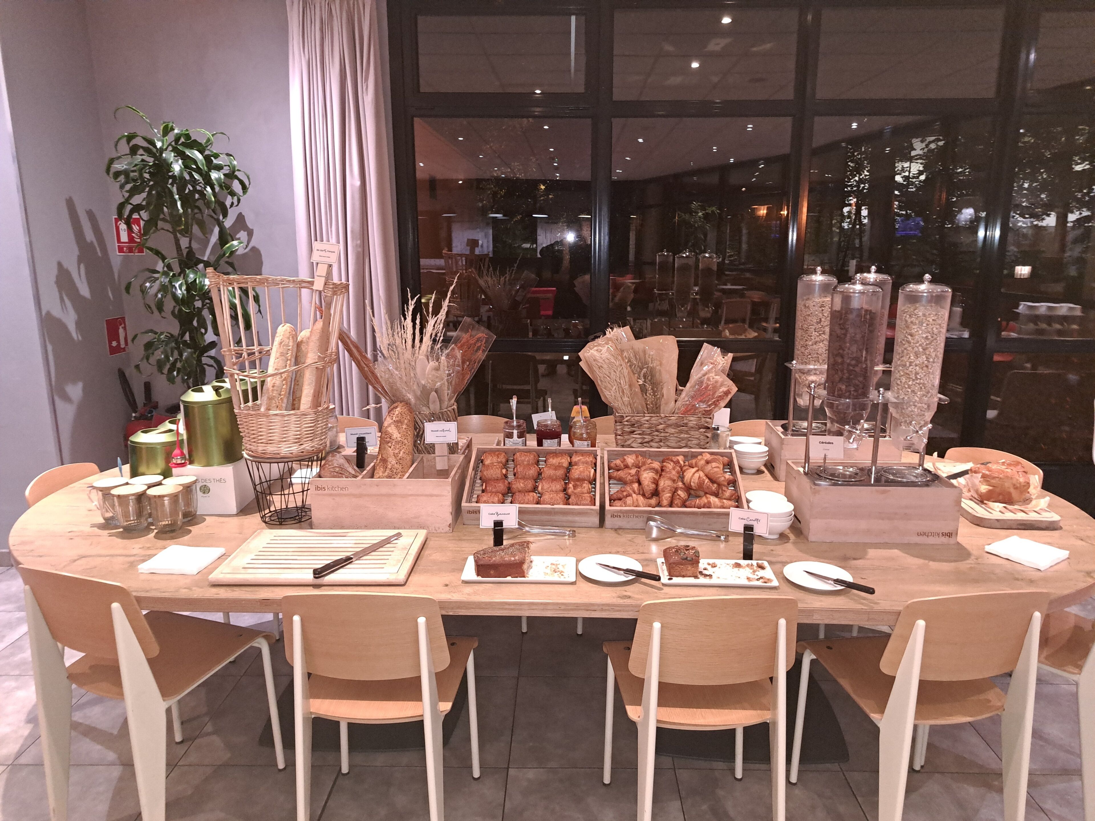 A breakfast buffet with various pastries, bread, and condiments.