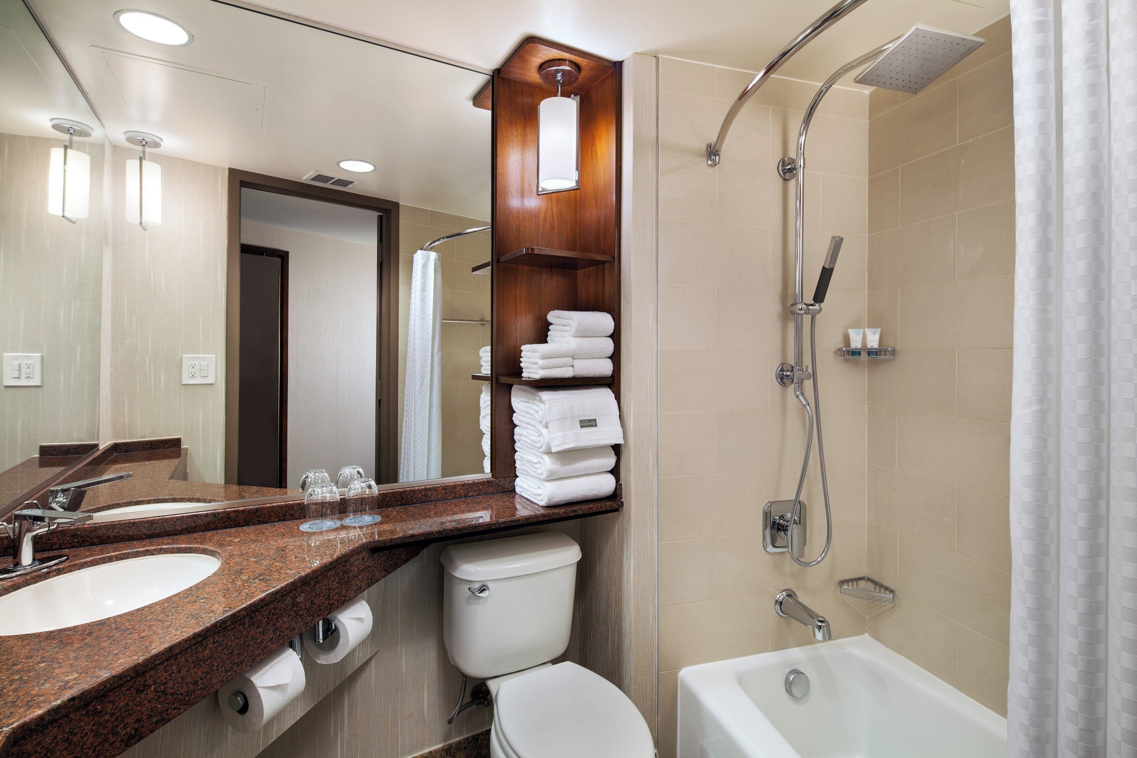 A modern bathroom with dual sinks, a toilet, a shower, and a bathtub.