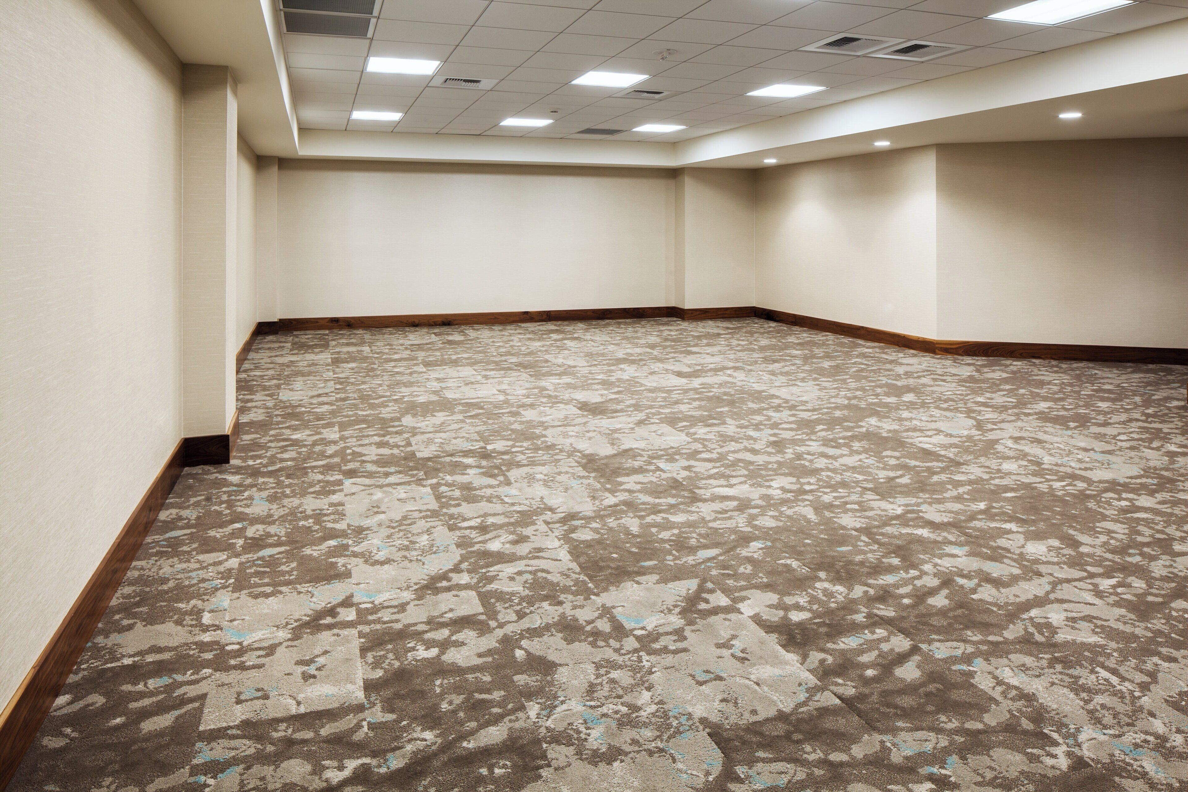 A large, empty conference room with a patterned carpet and wooden trim.