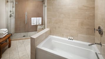 Une salle de bain moderne avec une douche à parois de verre, une baignoire blanche et un banc en bois.