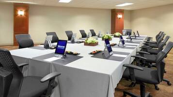 A conference room with a long table, multiple chairs, and laptops.