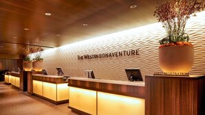 A hotel reception area with a modern design, featuring a textured wall and a guest registration desk. - The Westin Bonaventure Hotel and Suites, Los Angeles (Los Angeles)