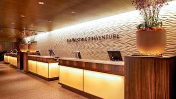 Welcome to the Westin Bonaventure Hotel, where a modern reception area awaits with a textured wall design and a prominent guest registration sign.