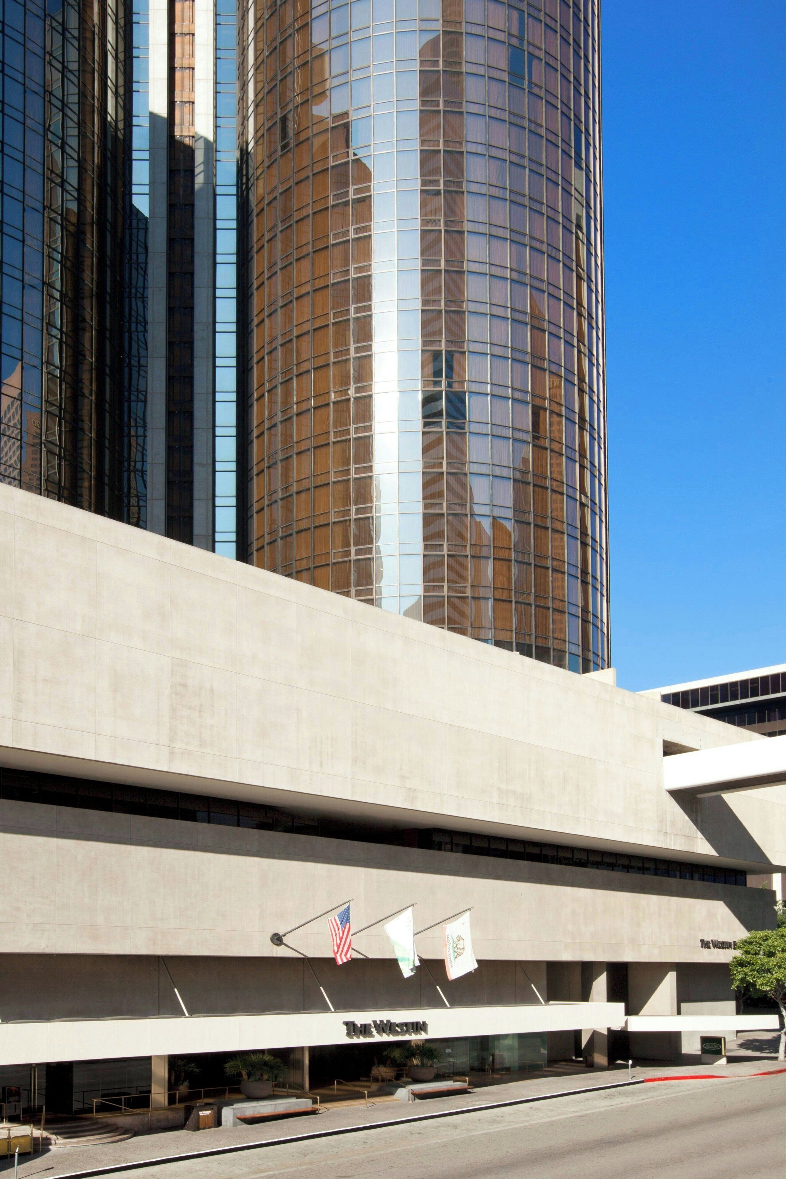 A modern building with a prominent glass facade reflecting the sky.