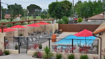 Una piscina al aire libre, sombrillas, tumbonas