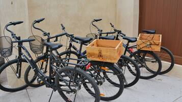 Una fila de bicicletas estacionadas contra una pared, cada una con una caja de madera sujeta en la parte trasera.