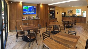 A spacious kitchen with wooden cabinets, a large TV, and a coffee station. - Casa Ojai Inn (Ojai)