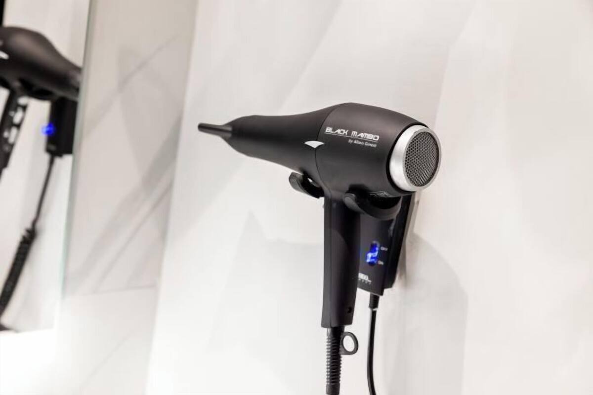 A hair dryer with a digital display, a cord, and a power plug.