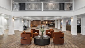 A spacious lobby with a central seating area, a staircase, and a reception desk. - Crowne Plaza Louisville Airport Expo Ctr by IHG (Louisville)