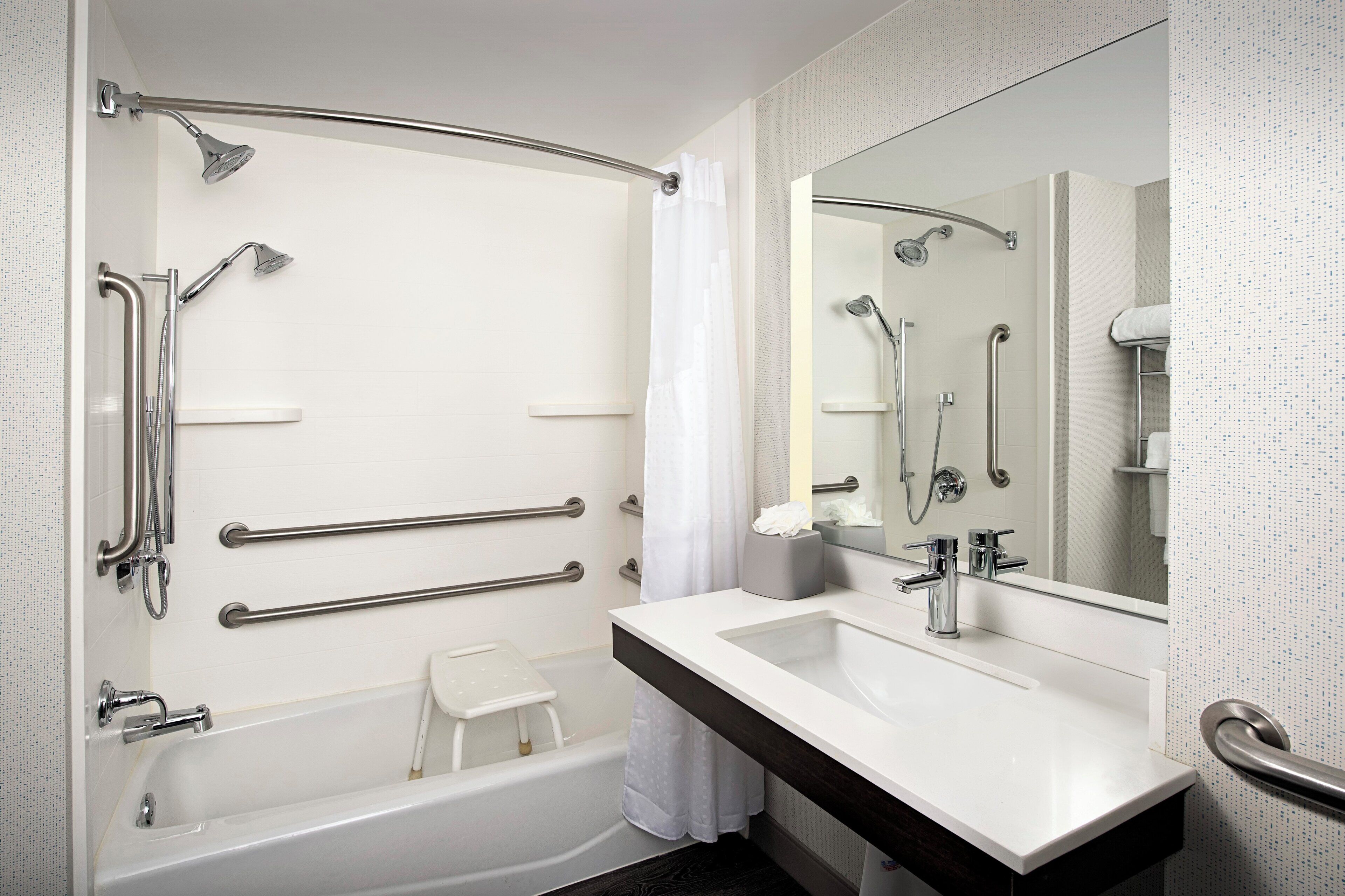 A modern bathroom with a bathtub, shower, and vanity.