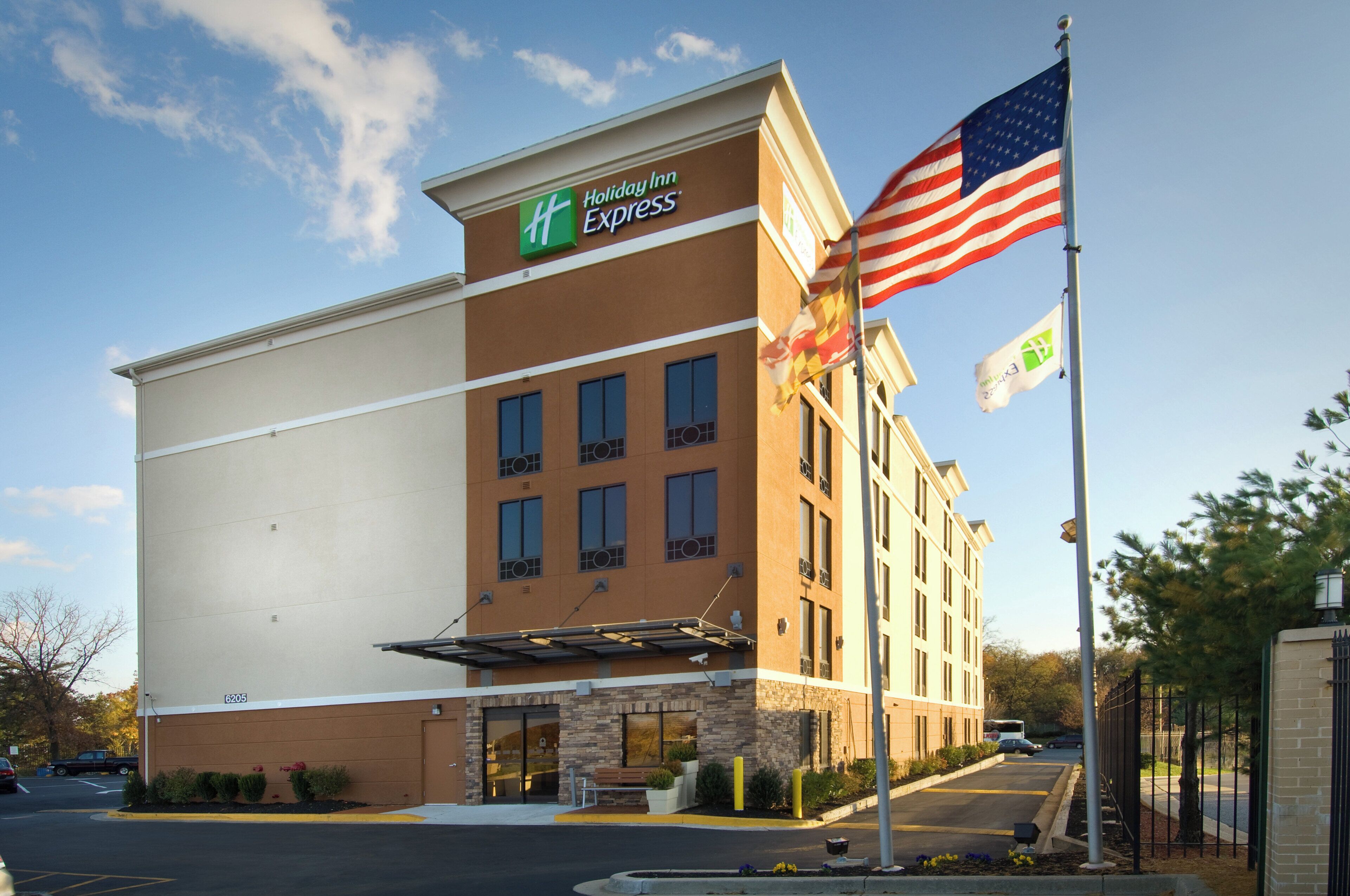 A Holiday Inn Express hotel with a brick facade, a flat roof, and a flagpole with the American flag.