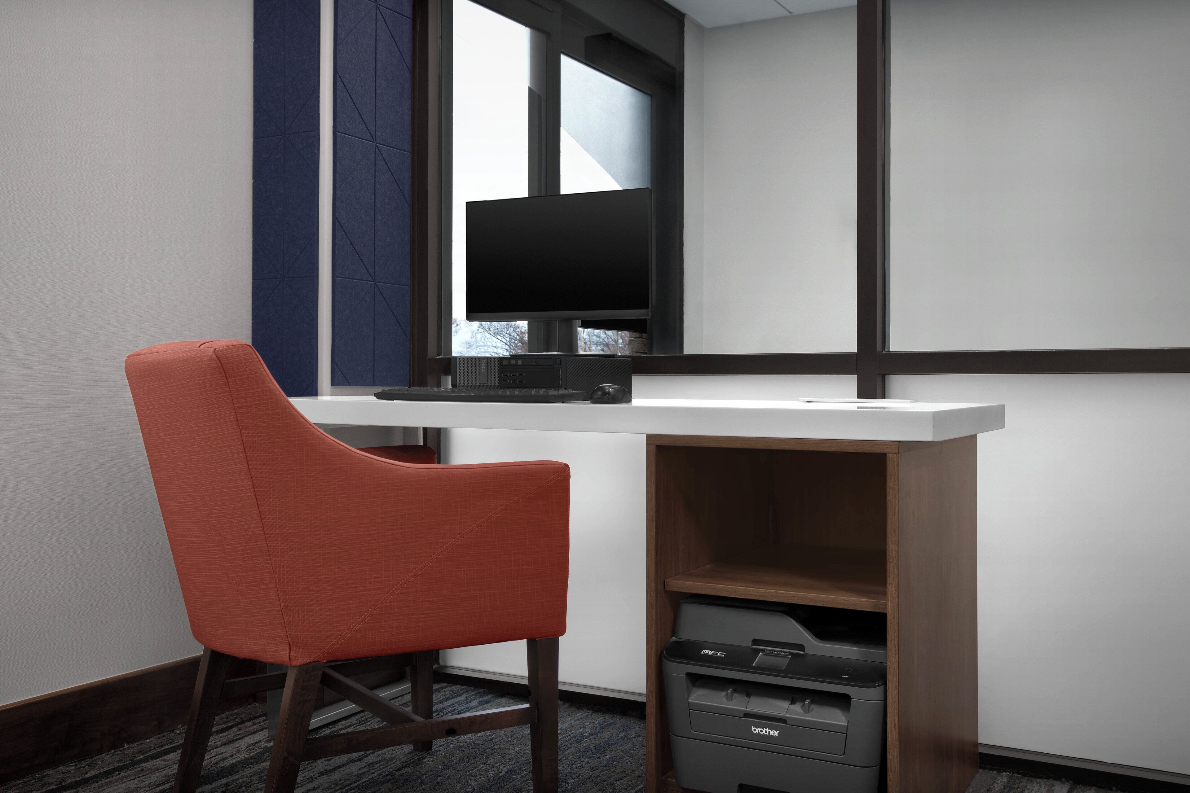 Un espace de bureau moderne comprenant un bureau, un ordinateur et une imprimante.