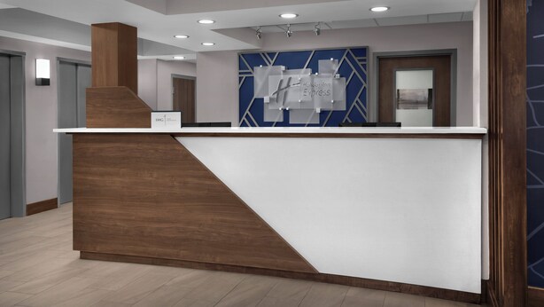 A reception desk with a modern design, featuring a wooden accent and a white top. - Holiday Inn Express Washington DC - BW Parkway by IHG (Hyattsville)