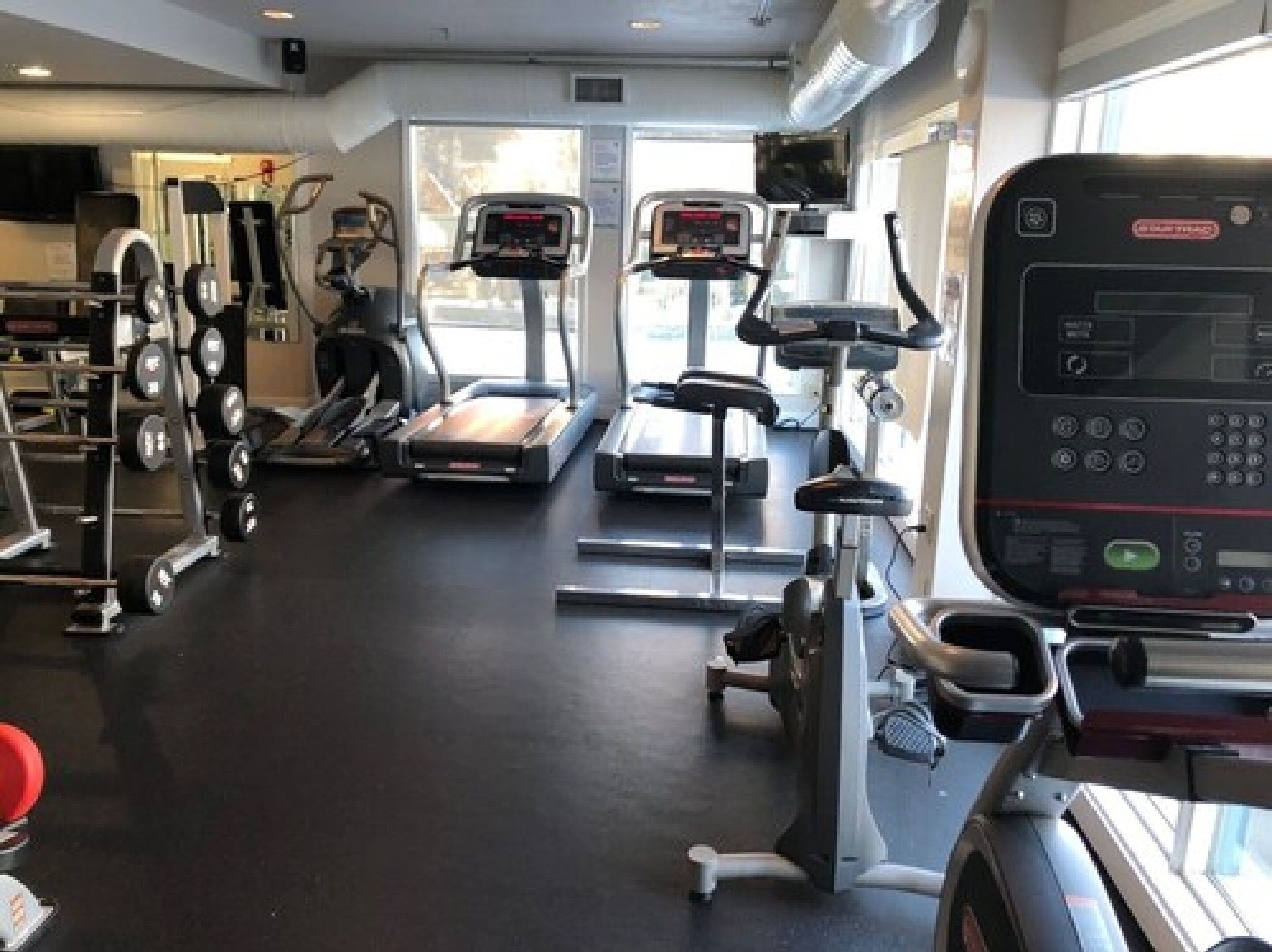 A gym with treadmills, elliptical machines, and weightlifting equipment.