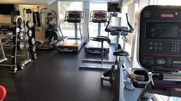 A gym with treadmills, elliptical machines, and weightlifting equipment.
