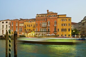 Un edificio storico con diversi piani, un ingresso evidente e un cartello che indica che si tratta di un hotel.