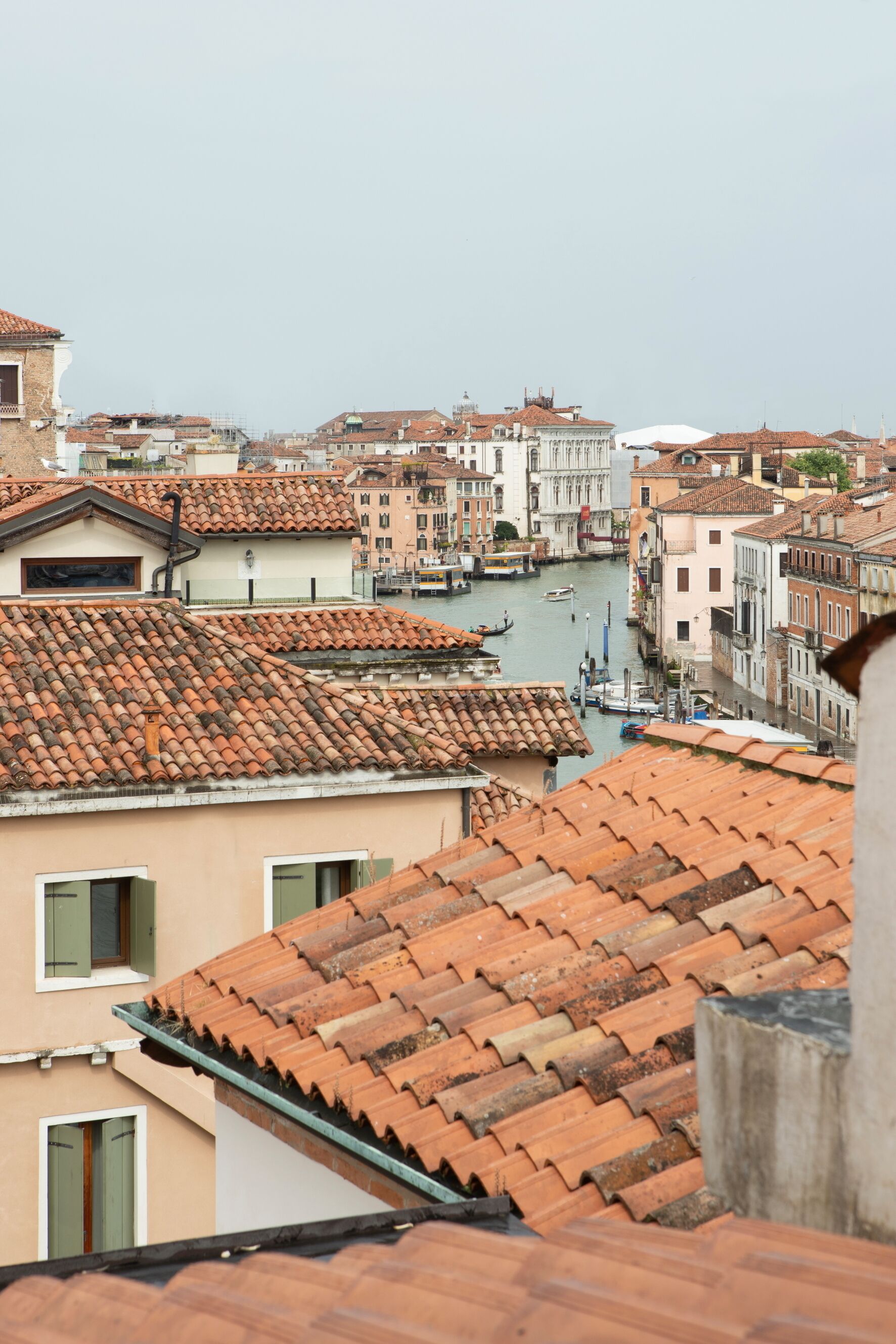 A view of Venice's historic buildings with terracotta roofs and a canal.