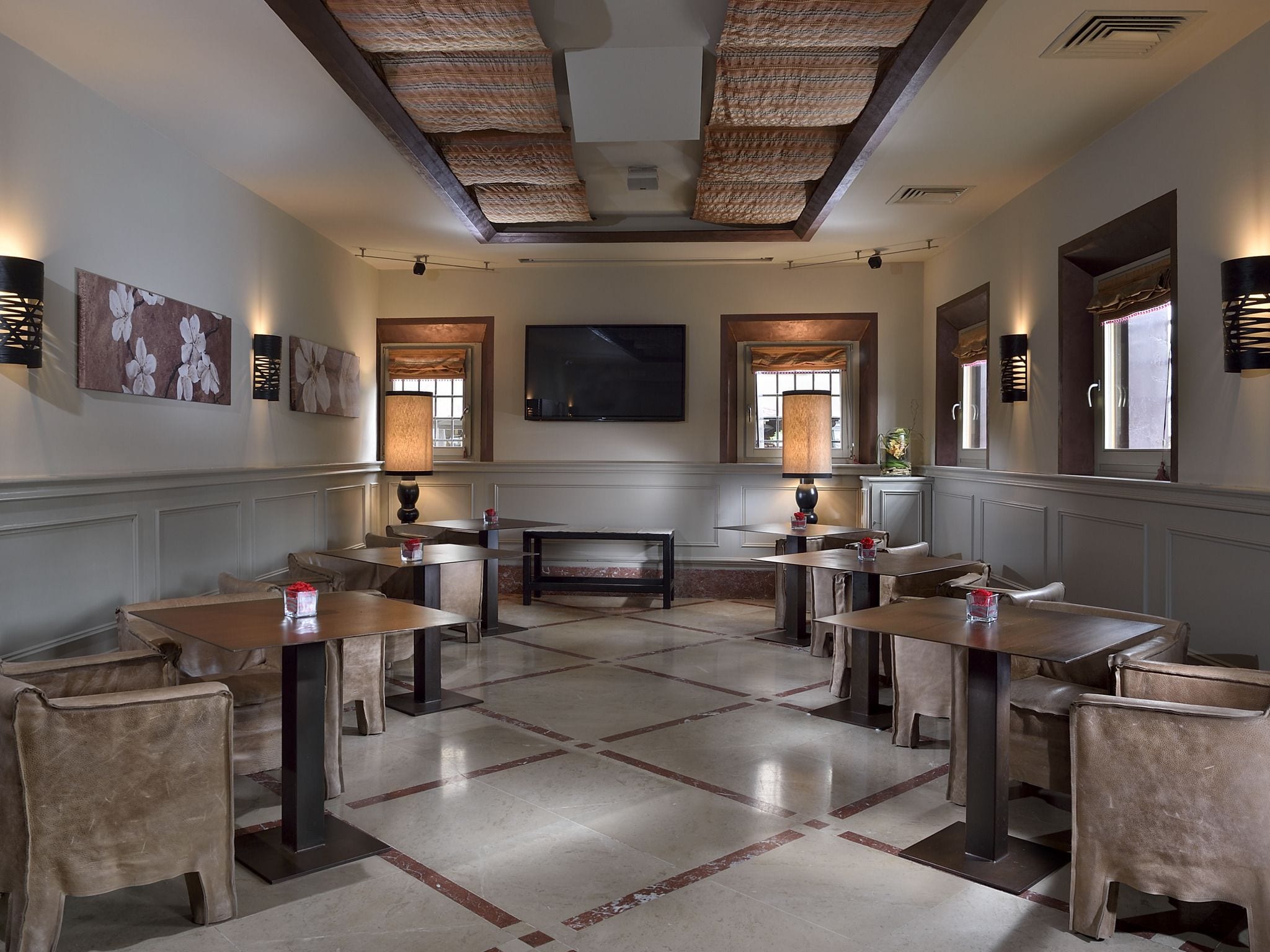 A dining area with multiple tables and chairs, a fireplace, and artwork on the walls.