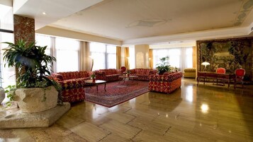 Un amplio hall con una gran zona de estar, una mesa de centro y un cuadro en la pared.