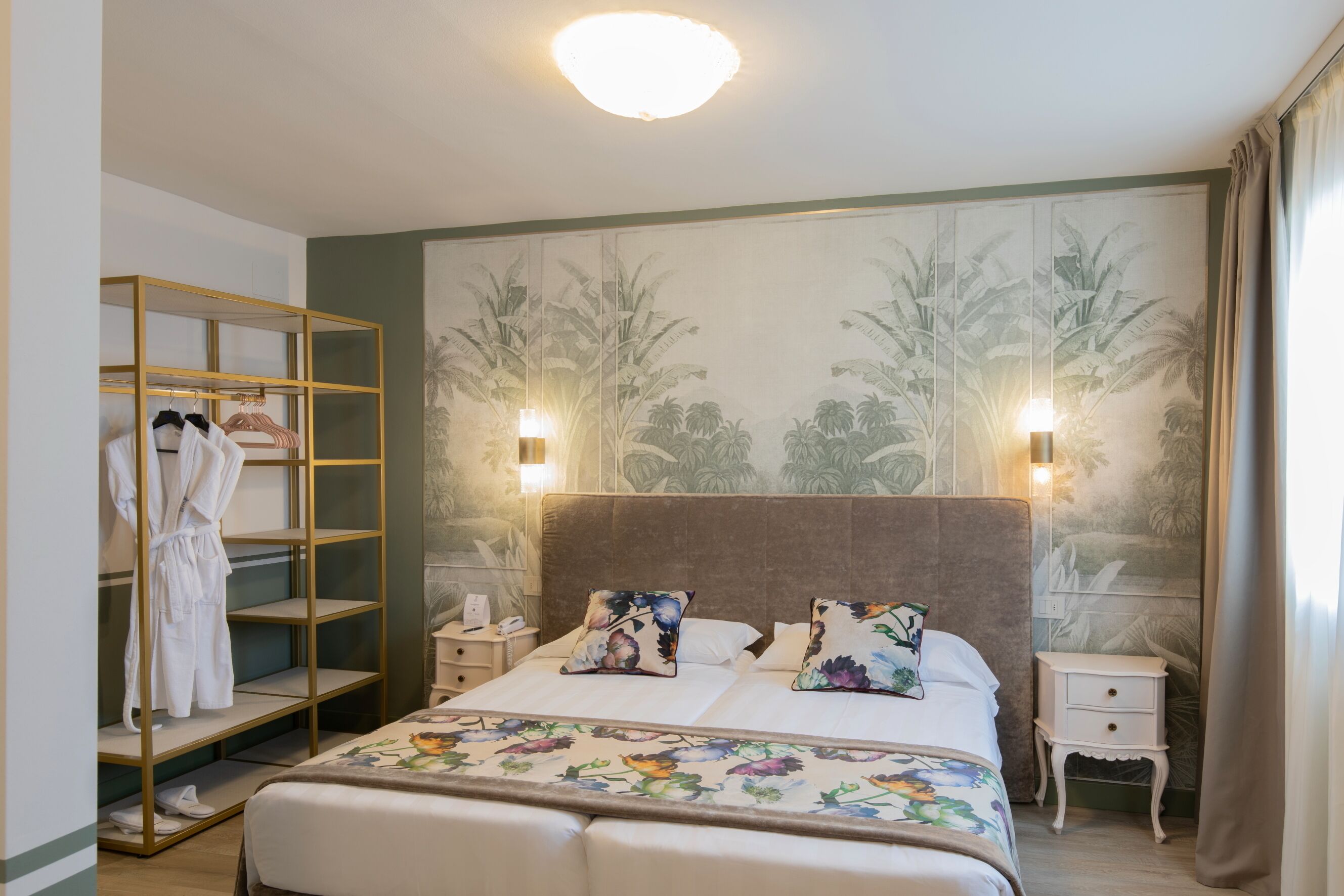 Een hotelkamer met een bed, een kledingkast en een nachtkastje.