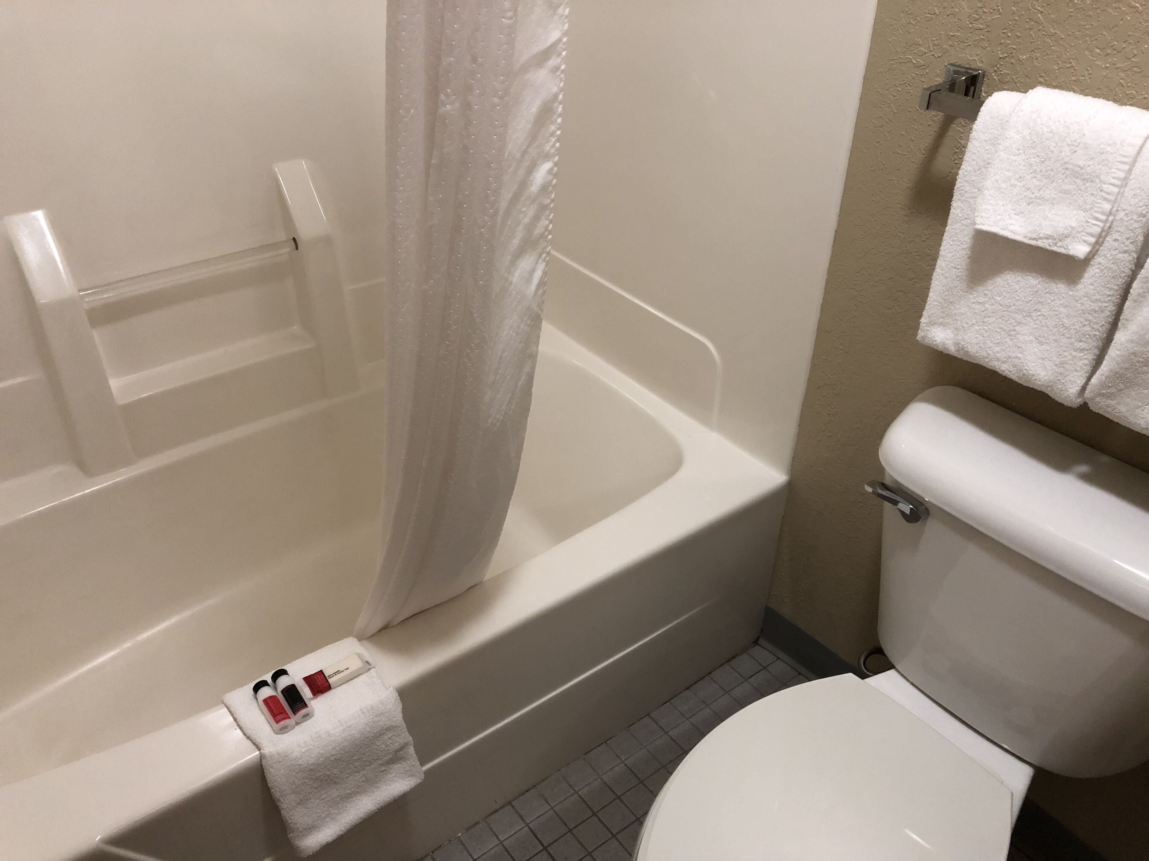 Un baño con bañera, inodoro y perchero para toallas.
