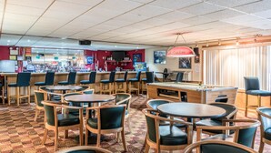A bar area with multiple seating arrangements, a pool table, and a bar counter. - Days Inn by Wyndham Carlisle North (Carlisle)