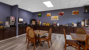 A breakfast area with a counter, coffee machines, and seating. - Days Inn by Wyndham Carlisle North (Carlisle)