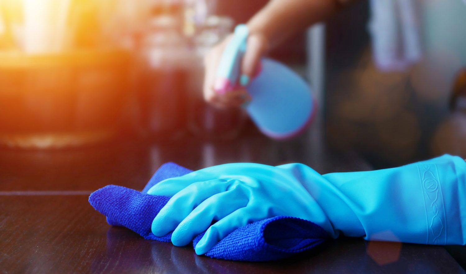 Una mano con un guante azul descansando sobre una superficie de madera.