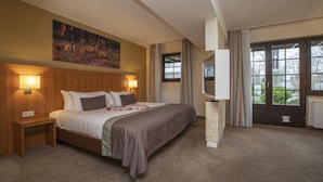 A hotel room with a large bed, a nightstand, a TV, and a painting on the wall. - Fletcher Hotel - Restaurant De Klepperman (Hoevelaken)
