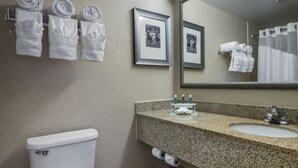 A bathroom with a toilet, sink, and towel rack with towels.