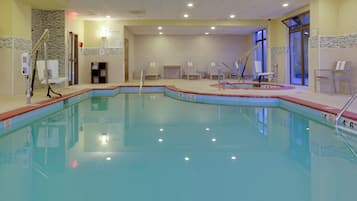 Una piscina interior con agua cristalina, marcas de profundidad y varias pistas.