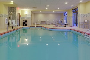 Uma piscina interior com água cristalina, linhas de profundidade marcadas e várias pistas.
