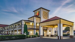 Ein Hotel mit einem zentralen Turm, mehreren Balkonen und einem überdachten Parkbereich.
