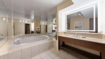 Ein modernes Badezimmer mit einer großzügigen freistehenden Badewanne, einem Doppelwaschtisch mit Spiegel und einem Fliesenboden.