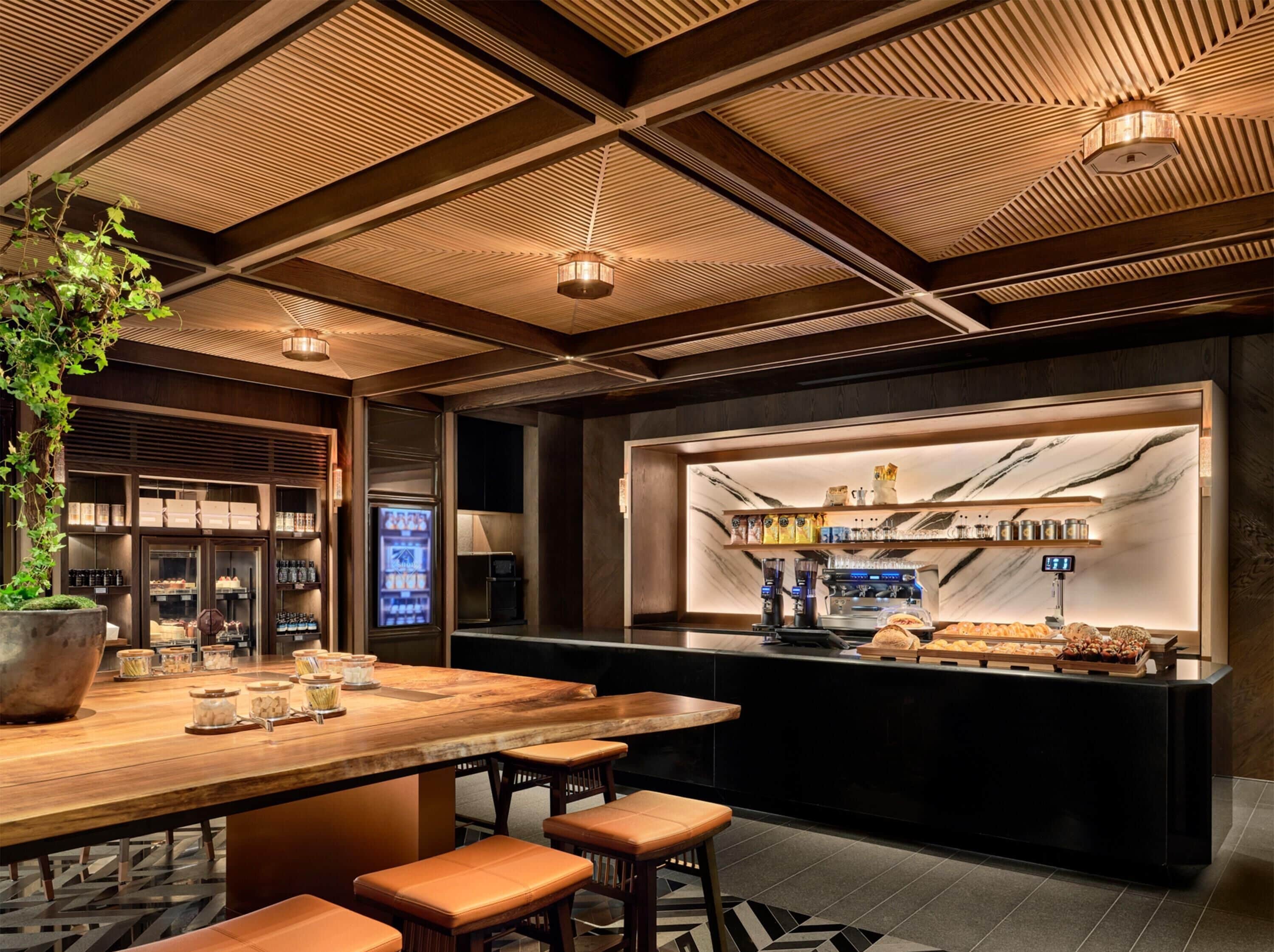 Zona de bar con mostrador de madera, asientos y una selección de bebidas.