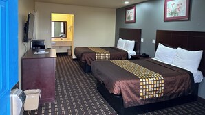 A hotel room with two beds, a desk, a mirror, and a trash bin. - Executive Inn & Suites (Prescott)