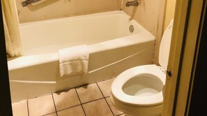 A bathroom with a bathtub, toilet, and grab bars. - Executive Inn & Suites (Prescott)