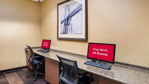 A reception desk with two monitors, a framed picture on the wall, and a sign indicating free Wi-Fi in all rooms. - Red Roof Inn Baltimore South - Glen Burnie (Glen Burnie)