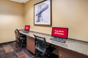 A reception desk with two monitors, a framed picture on the wall, and a sign indicating free Wi-Fi in all rooms. - Red Roof Inn Baltimore South - Glen Burnie (Glen Burnie)