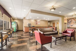 A hotel lobby with a reception desk, seating area, and a coffee station. - Red Roof Inn Baltimore South - Glen Burnie (Glen Burnie)