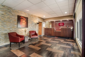 A reception area with a Red Roof Inn sign, a reception desk, and two leather chairs. - Red Roof Inn Baltimore South - Glen Burnie (Glen Burnie)